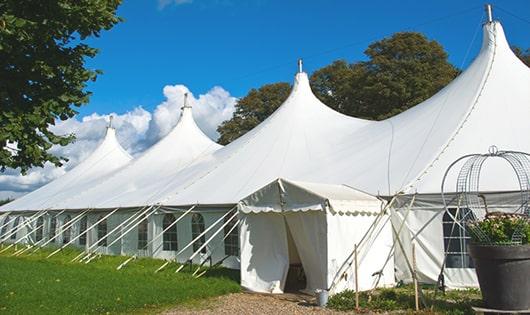 tall green portable restrooms assembled at a music festival, contributing to an organized and sanitary environment for guests in Lakebay