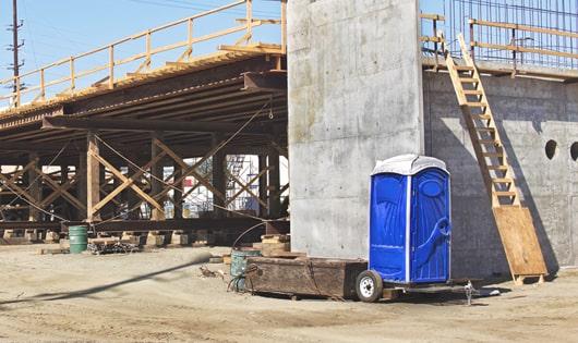 portable restrooms set up for workers’ use at a busy construction site